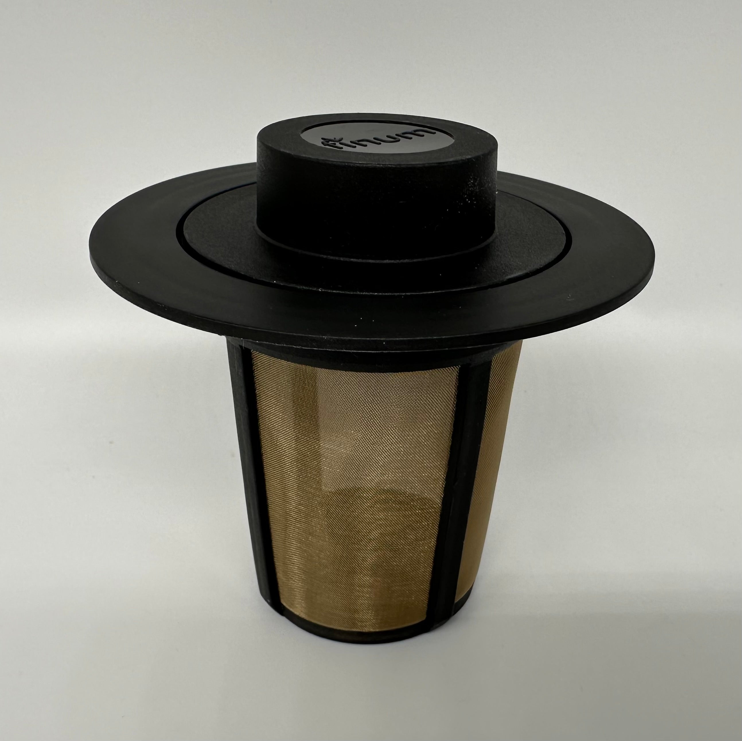 A black coffee cup with a shiny metal filter positioned inside, designed for brewing rich coffee.