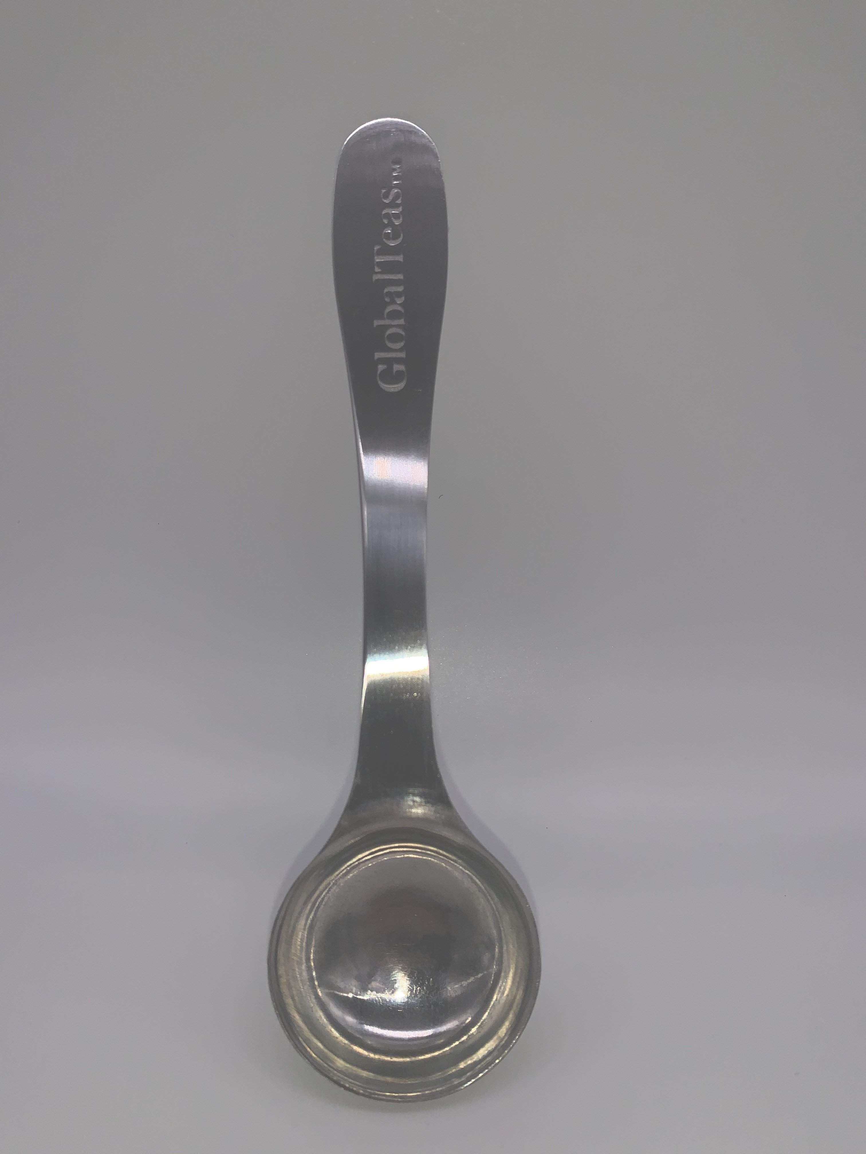 A shiny stainless steel spoon with the engraving "GlobalTeas" on the handle, featuring a rounded bowl and sleek design.