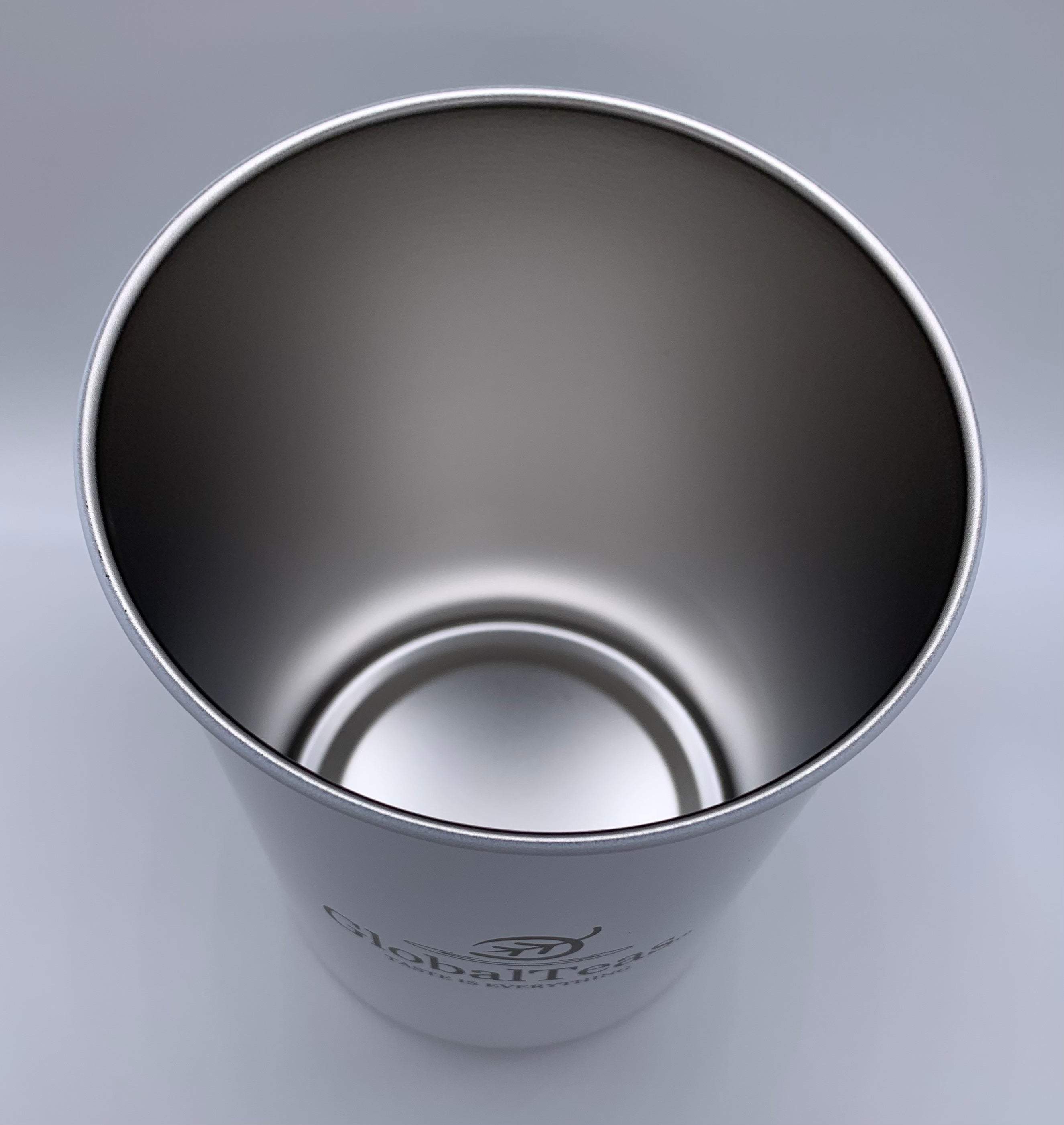 A sleek, stainless steel cup interior featuring the logo of Global Tea, viewed from above against a gray background.