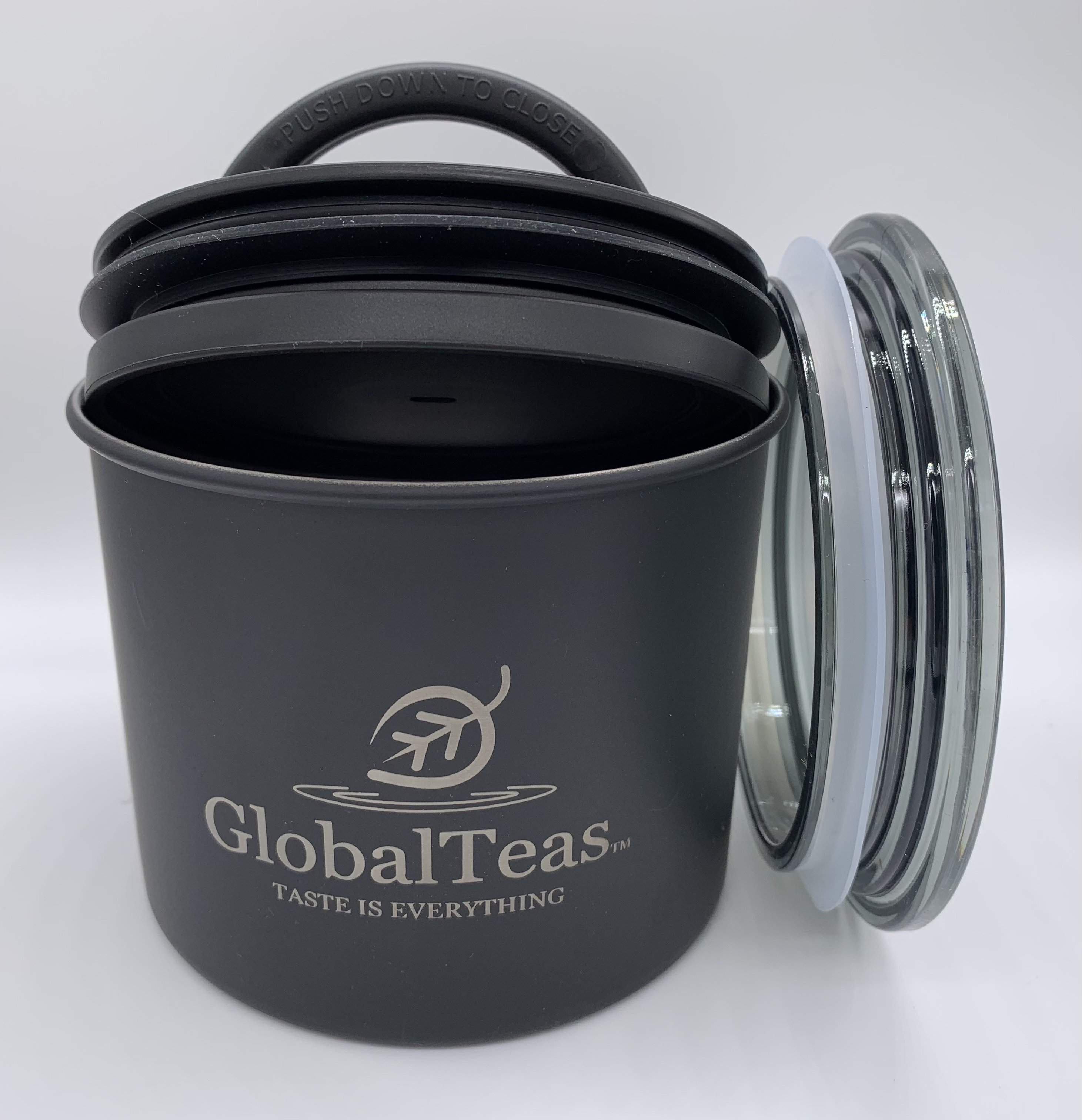 A black canister with a silicone lid and glass cover, featuring the GlobalTeas logo, designed for tea storage.